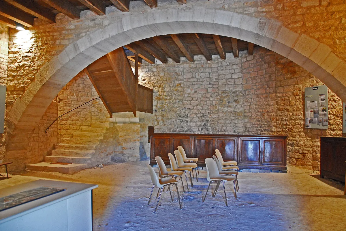Salle voûtée en pierre du rez-de-chaussée de la rotonde de Simiane-la-Rotonde, avec des chaises